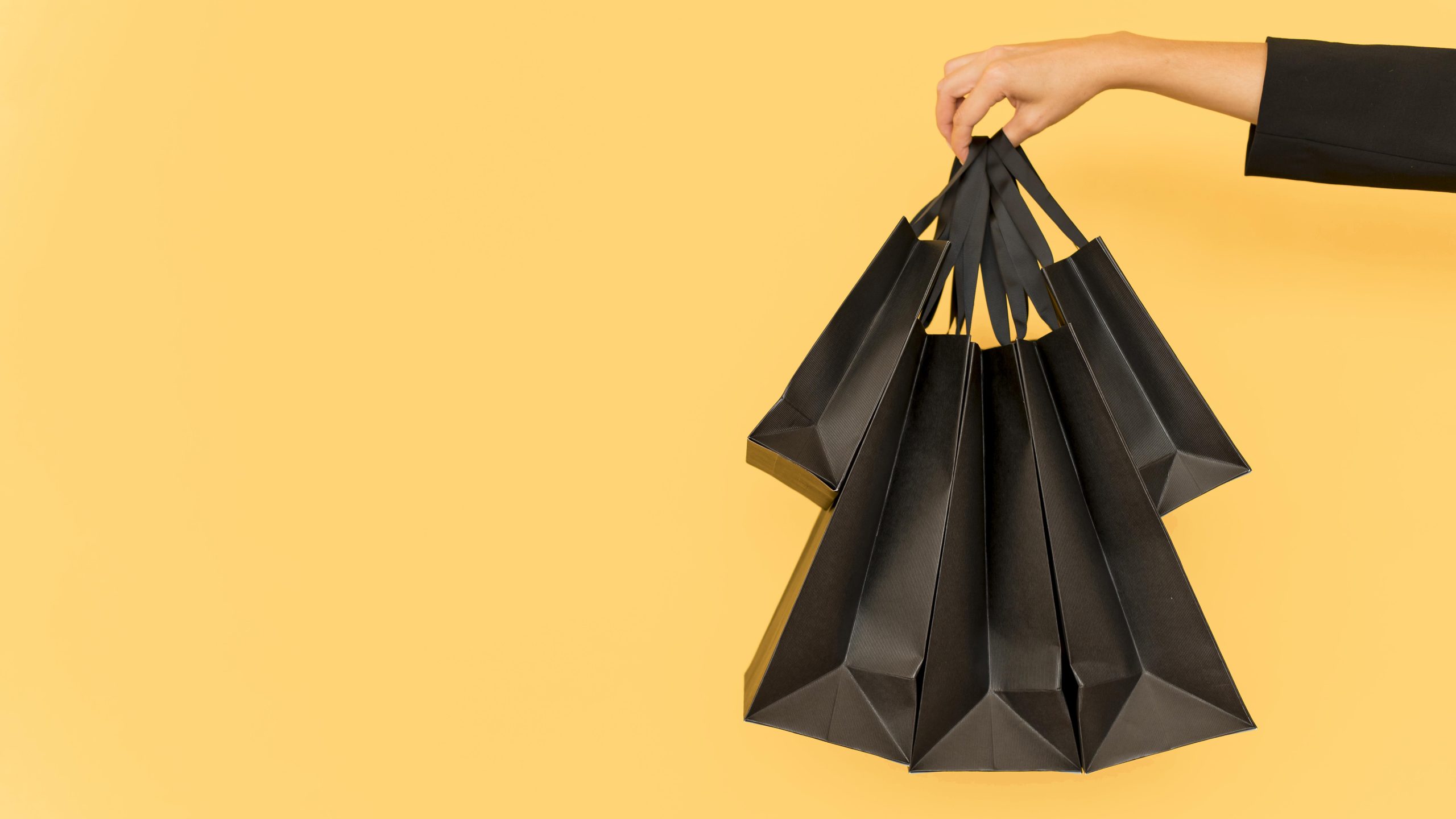 person-holding-various-sizes-black-shopping-bags